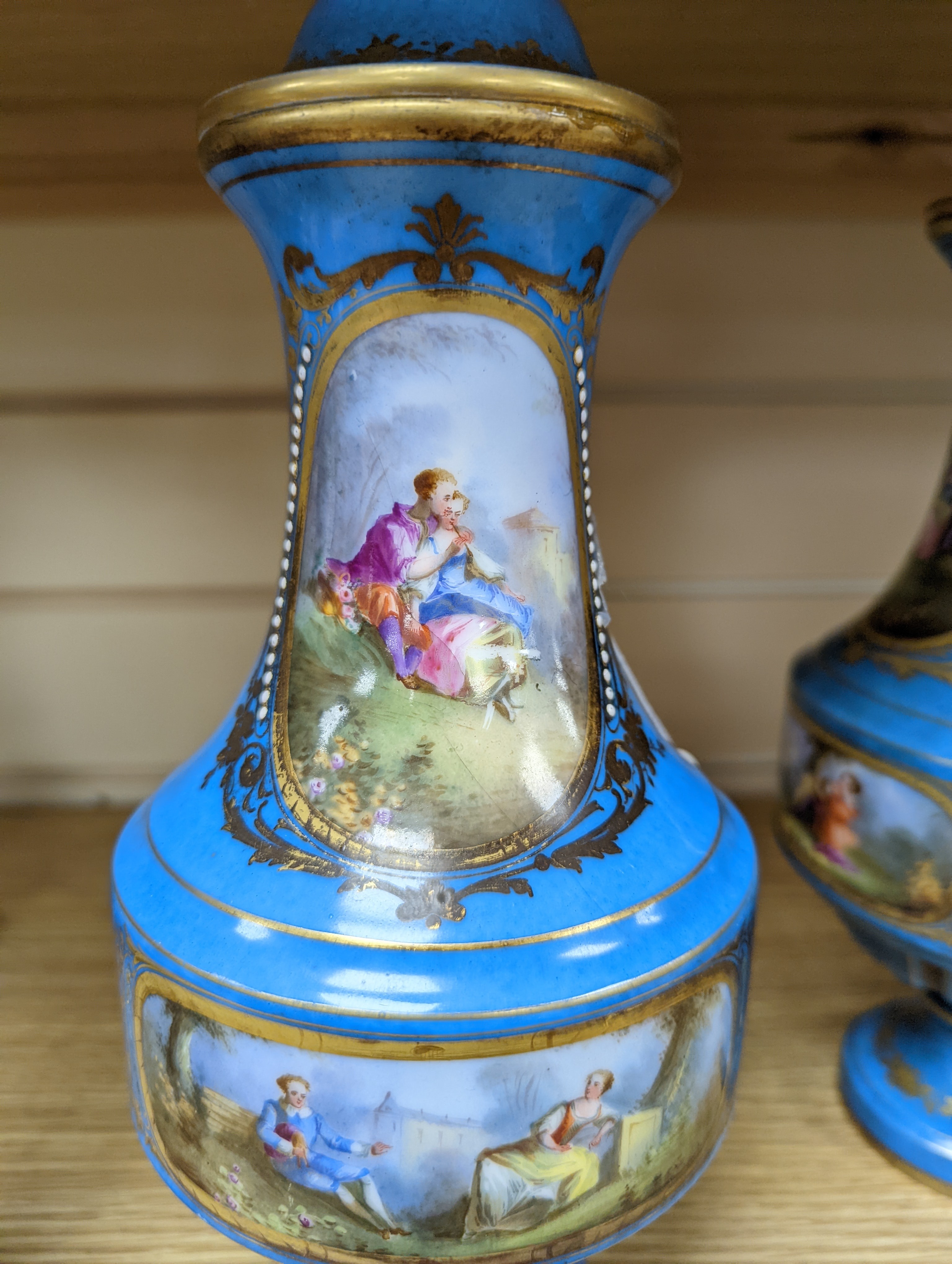 A pair of Sevres style porcelain bleu celeste ground vases and covers, 34cm